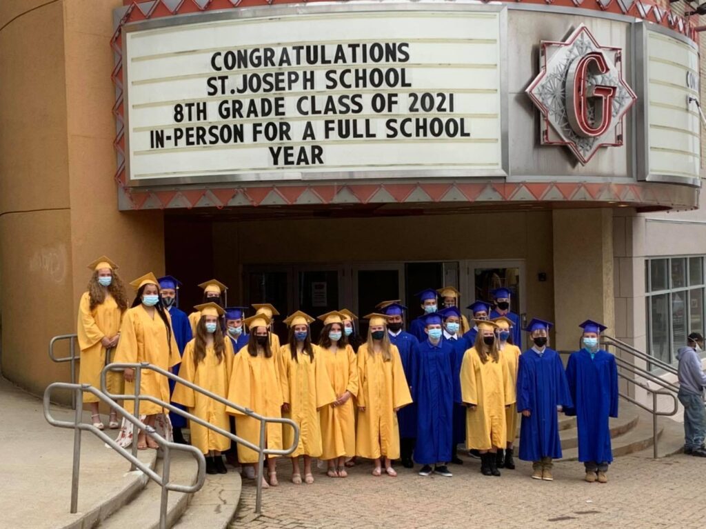 The Class of 2021 wearing masks under the marquis of the Garde Arts Center